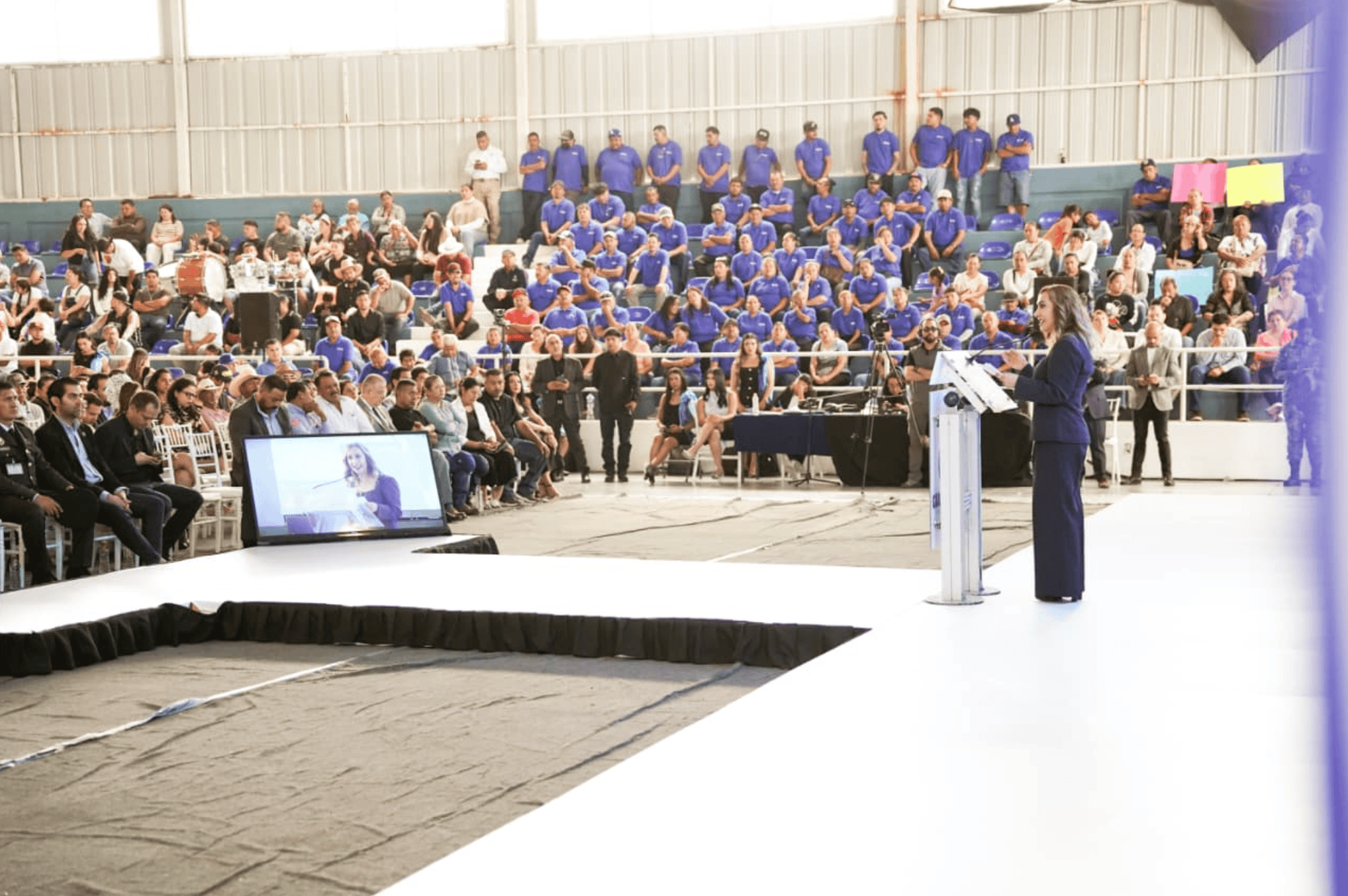 Evento turístico en Guanajuato con audiencia y oradora en escenario.