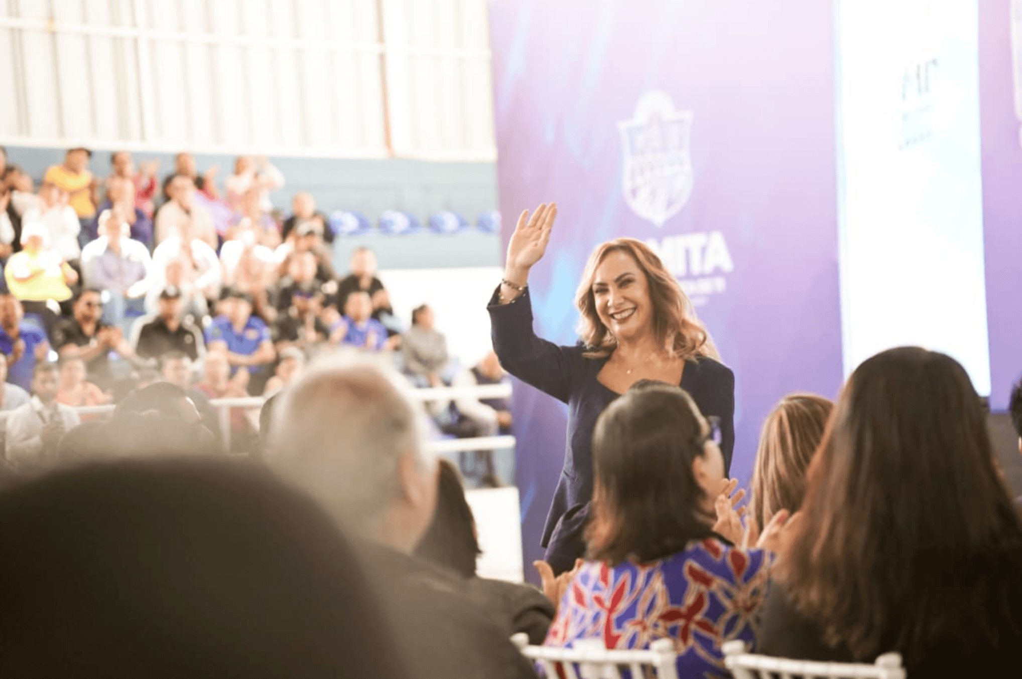 Mujer en evento turístico de Romita saludando a la audiencia.