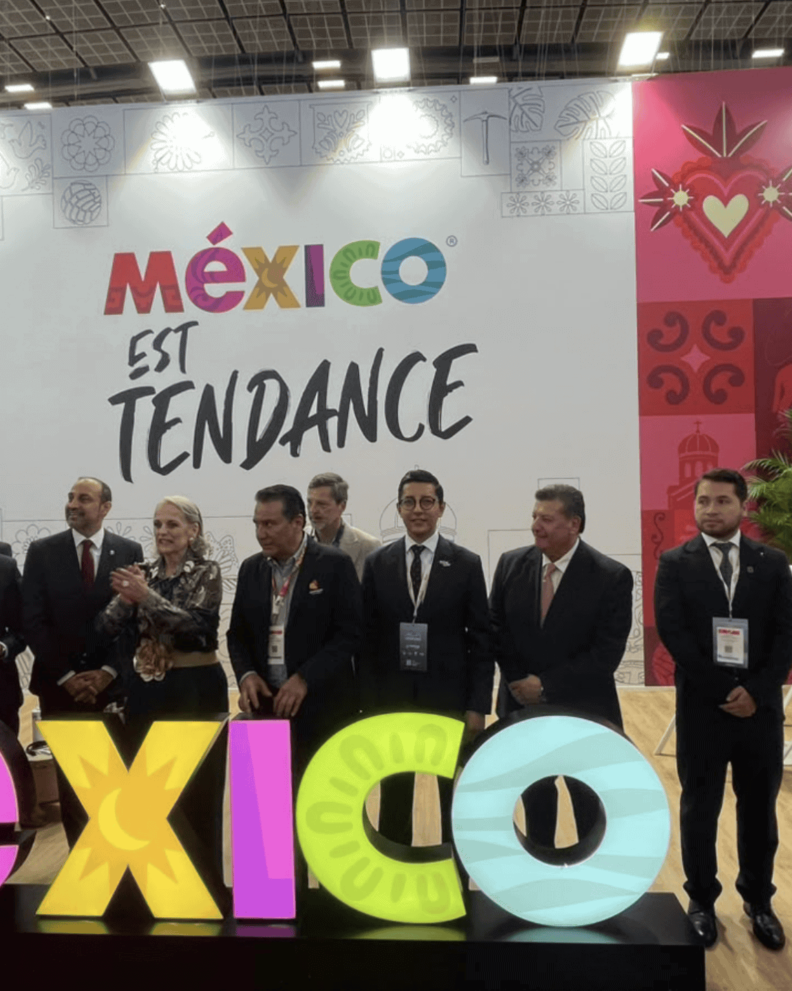 Representantes en la feria turística de México con el cartel de México en tendencia.