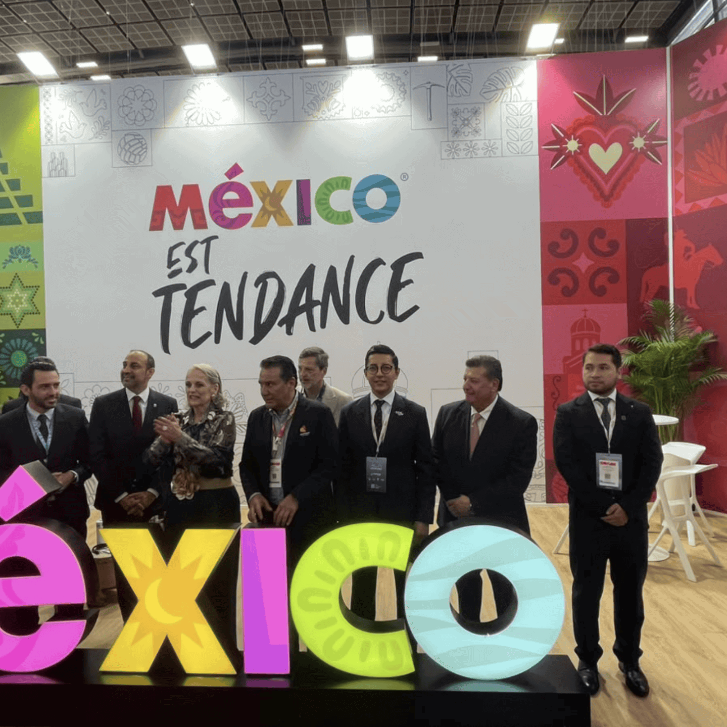 Representantes en la feria turística de México con el cartel de México en tendencia.