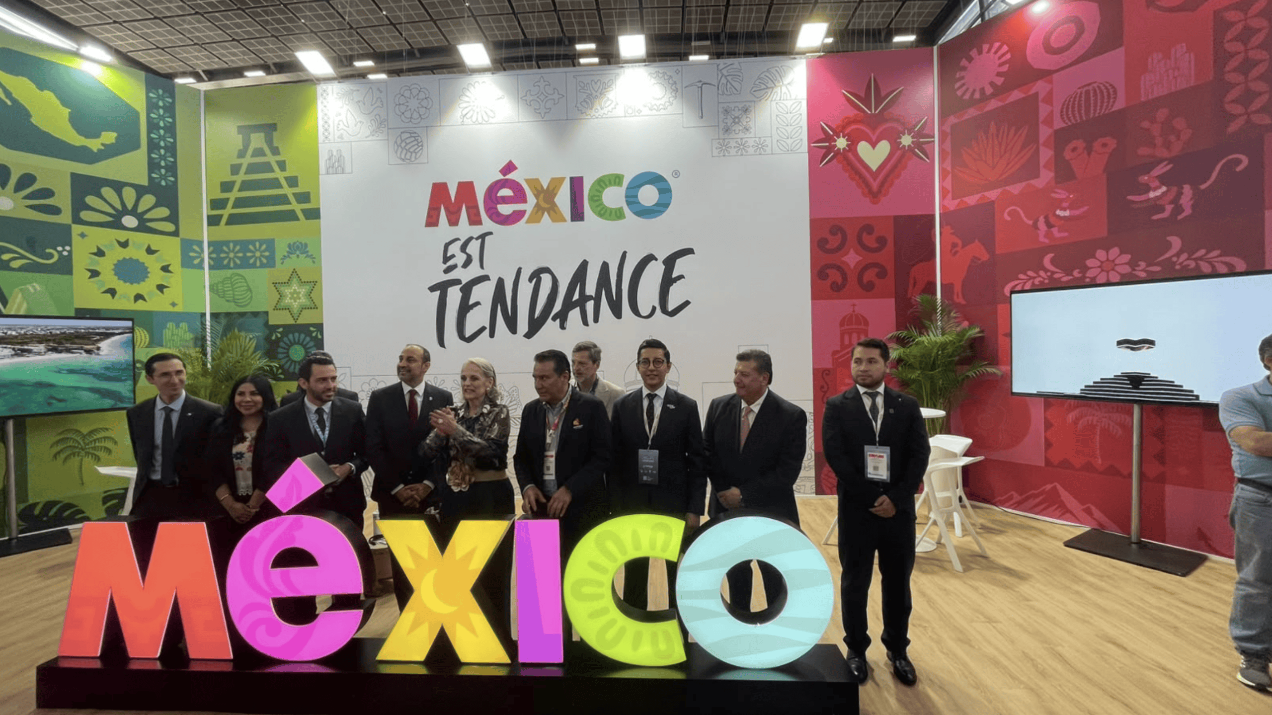 Representantes en la feria turística de México con el cartel de México en tendencia.