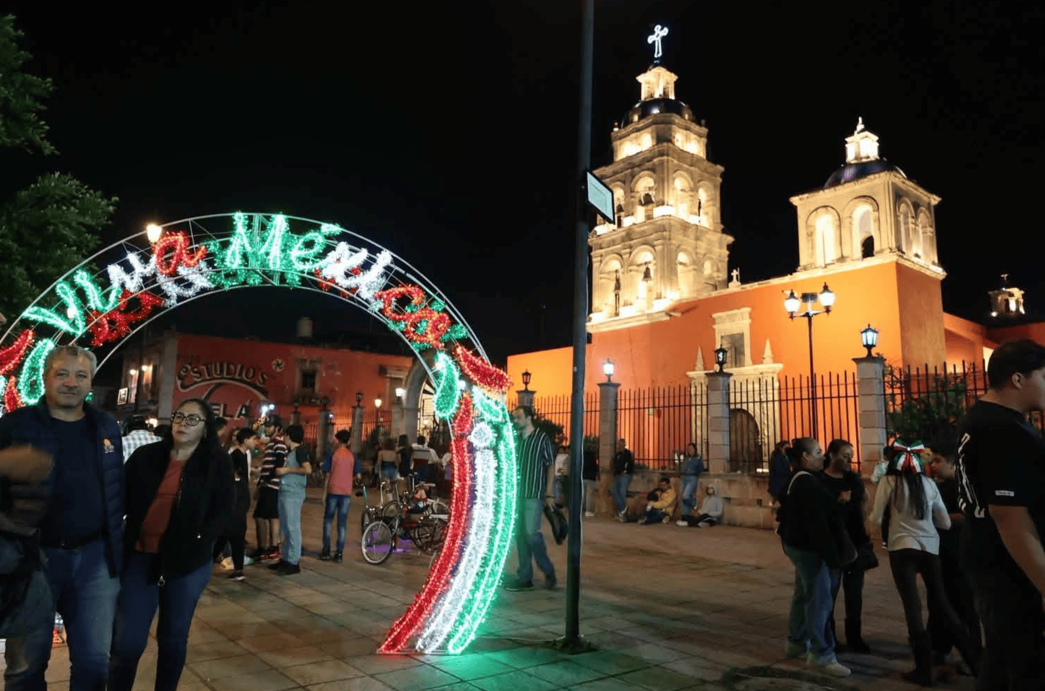Fiesta en San Miguel de Allende con luces y gente en la plaza.