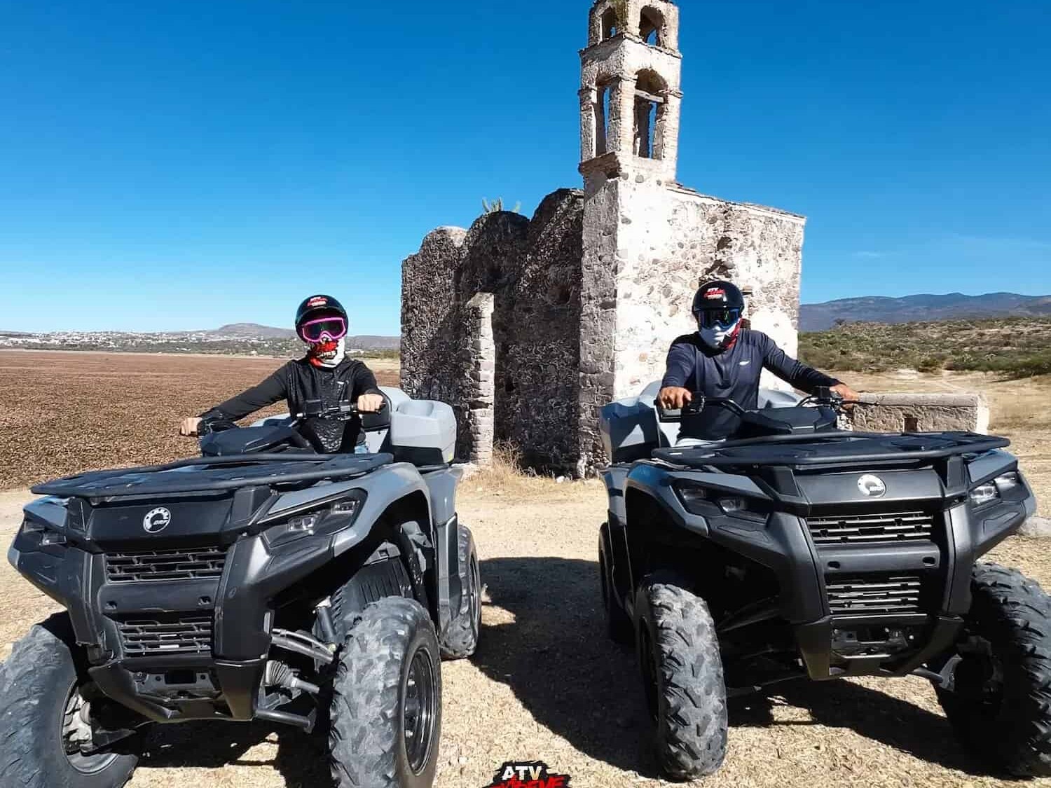 Couple on ATVs in front of a ruined stone chapel in the outskirts of San Miguel de Allende.