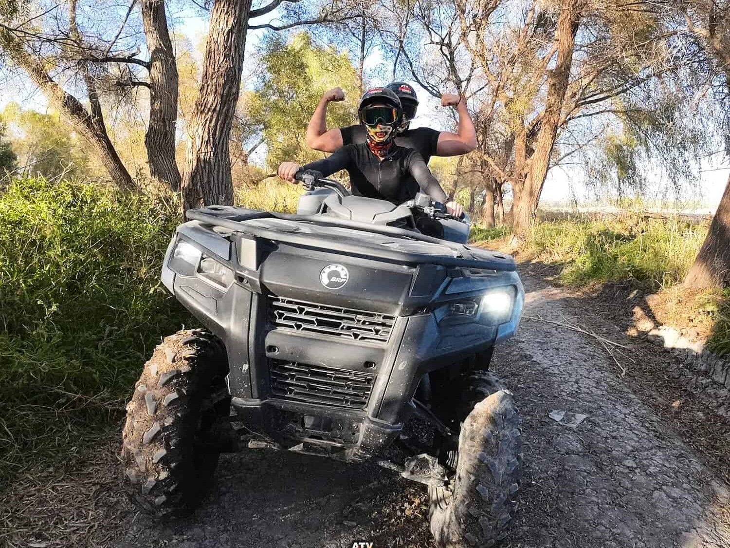 ATV moving along a path under the trees.
