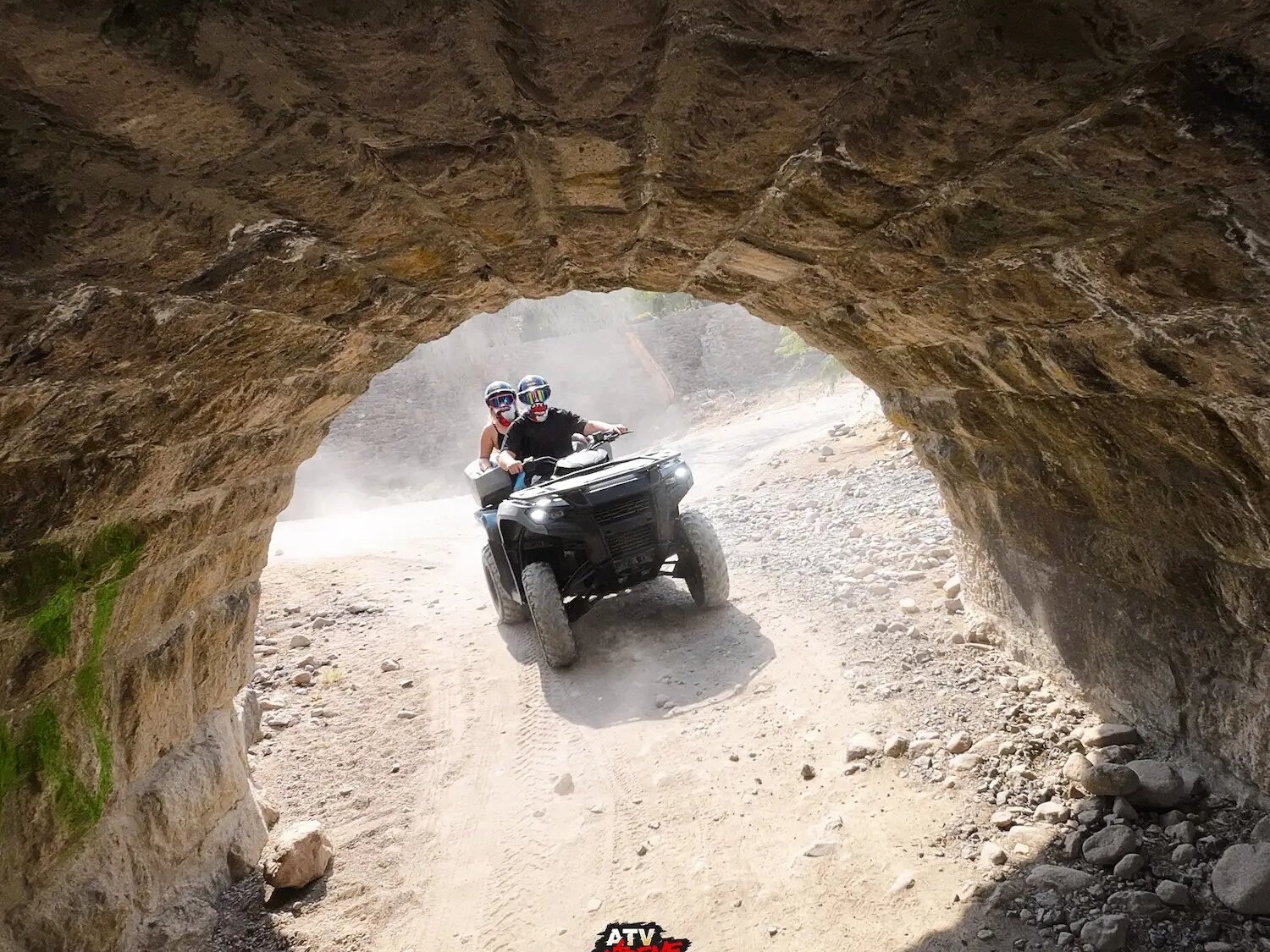 ATV emerging from a stone tunnel during a guided tour.