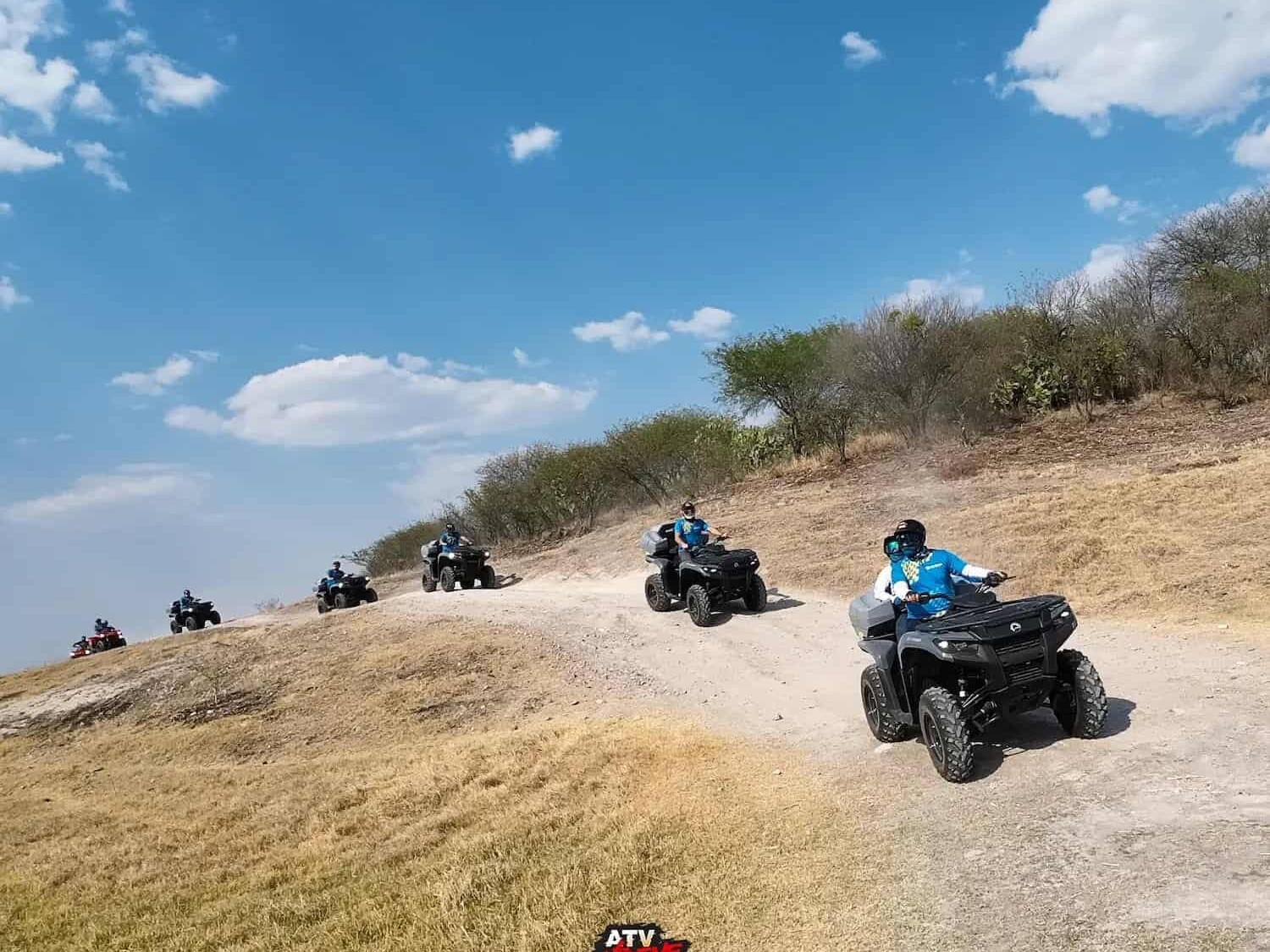 Line of ATVs traveling along a dirt path in the Guanajuato countryside.