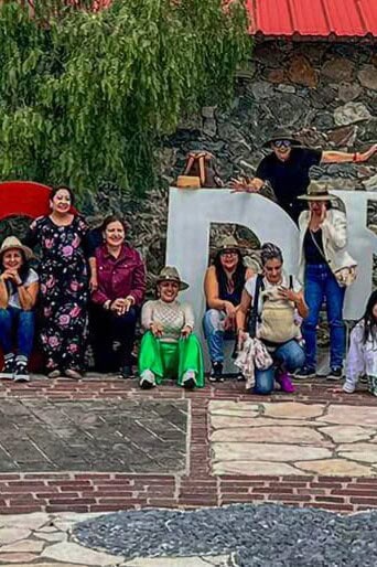Group of visitors in front of the monumental letters of the Barrio Mágico of Mineral de la Luz, Guanajuato.
