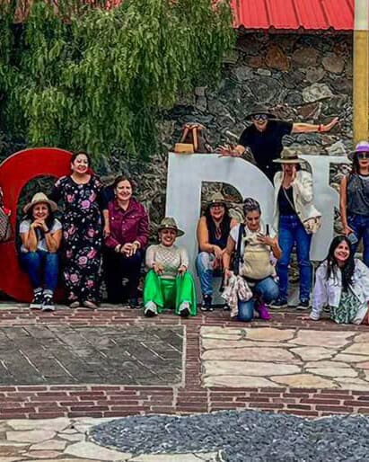 Grupo de visitantes frente a las letras monumentales del Barrio Mágico de Mineral de la Luz, Guanajuato.