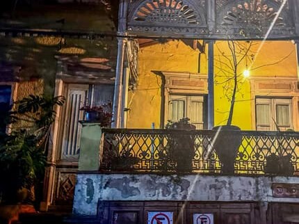 Balcón de hierro forjado de una casona iluminada de noche en el Paseo de la Presa, Guanajuato.