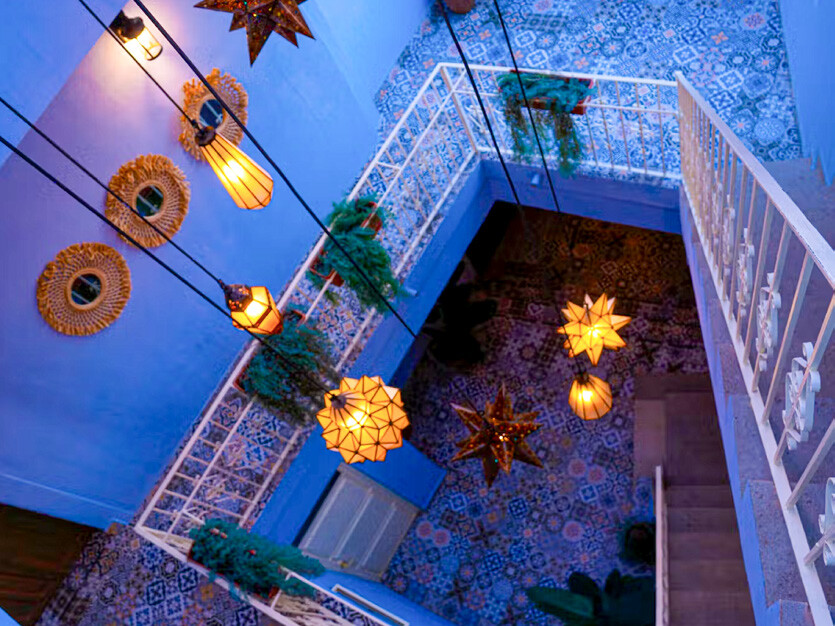 Interior patio with tiles, lanterns, and tin stars at a Grupo Corazón Mexicano hotel.