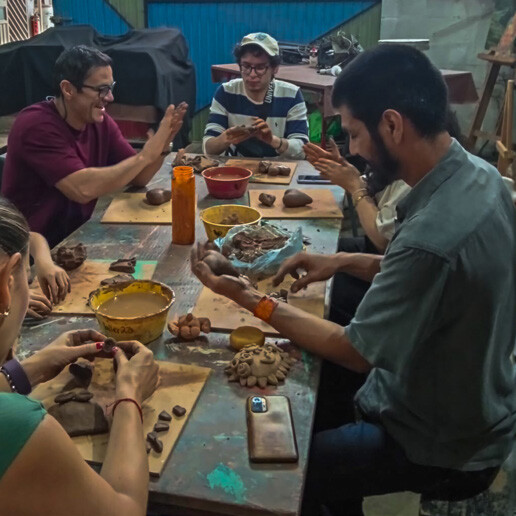Participants shaping clay figures in an artisanal workshop in Guanajuato.