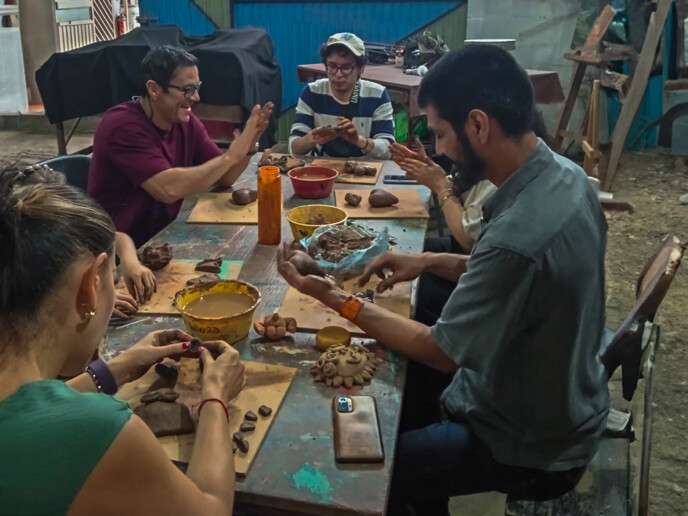 Participants shaping clay figures in an artisanal workshop in Guanajuato.