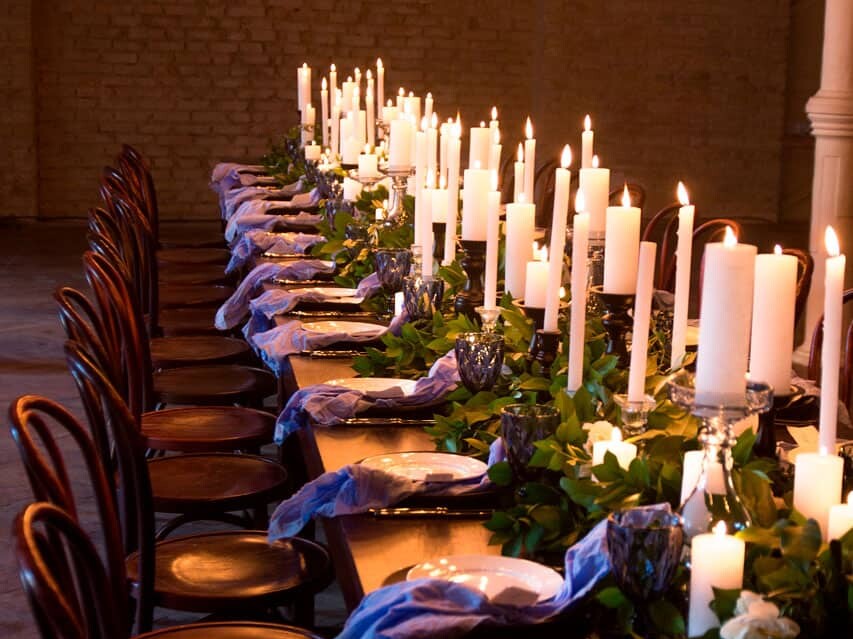 Long table set with candles and foliage for a chef's tasting dinner.