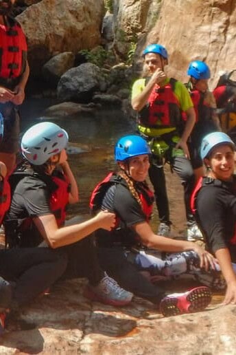 Group wearing helmets and life jackets during a canyoning tour in a canyon in Guanajuato.
