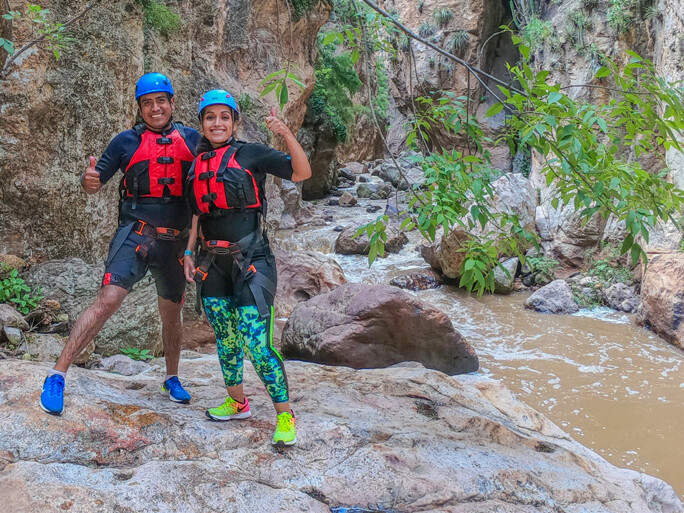 Couple with canyoning gear by a stream in a canyon in Guanajuato.