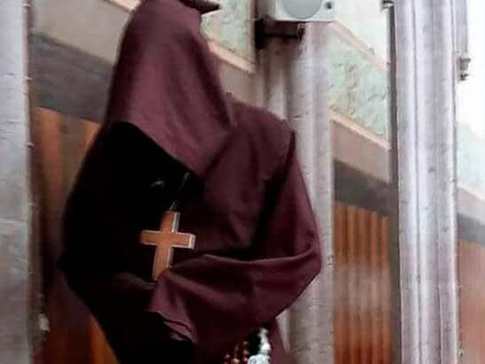 Person with religious habit and cross in Guanajuato, cultural tourism.