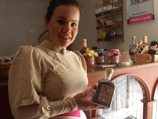 Mujer sosteniendo botella de licor en tienda de Guanajuato, México.