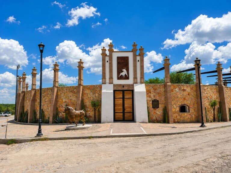 Fachada de piedra con escultura de un caballo bajo el cielo azul.