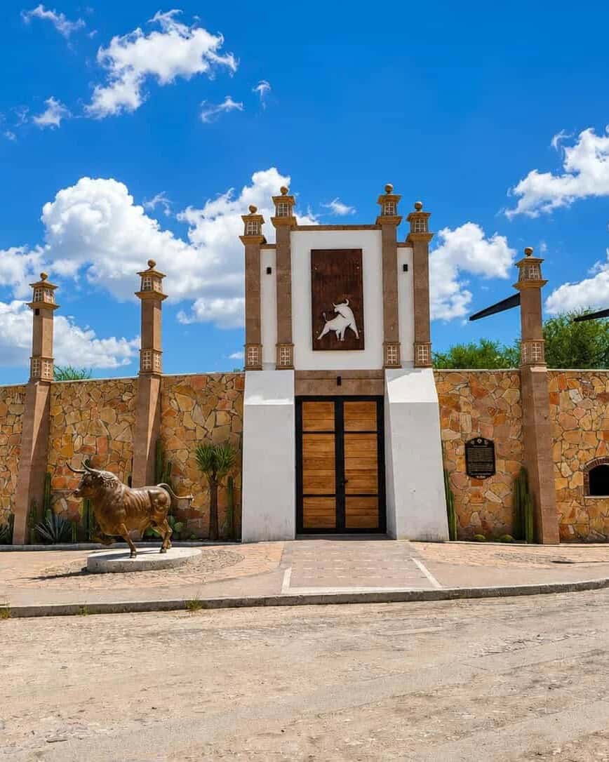 Stone facade with a sculpture of a horse under the blue sky.