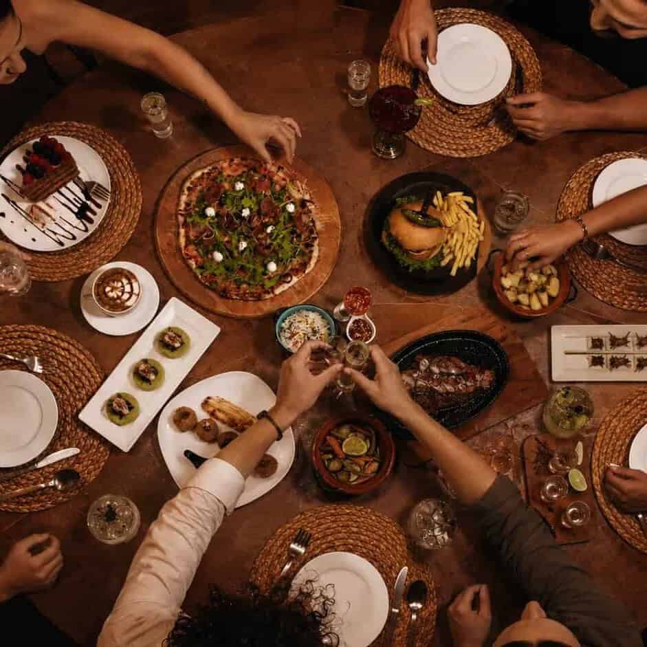 Group of travelers sharing Mexican dishes at a wooden table, seen from above.