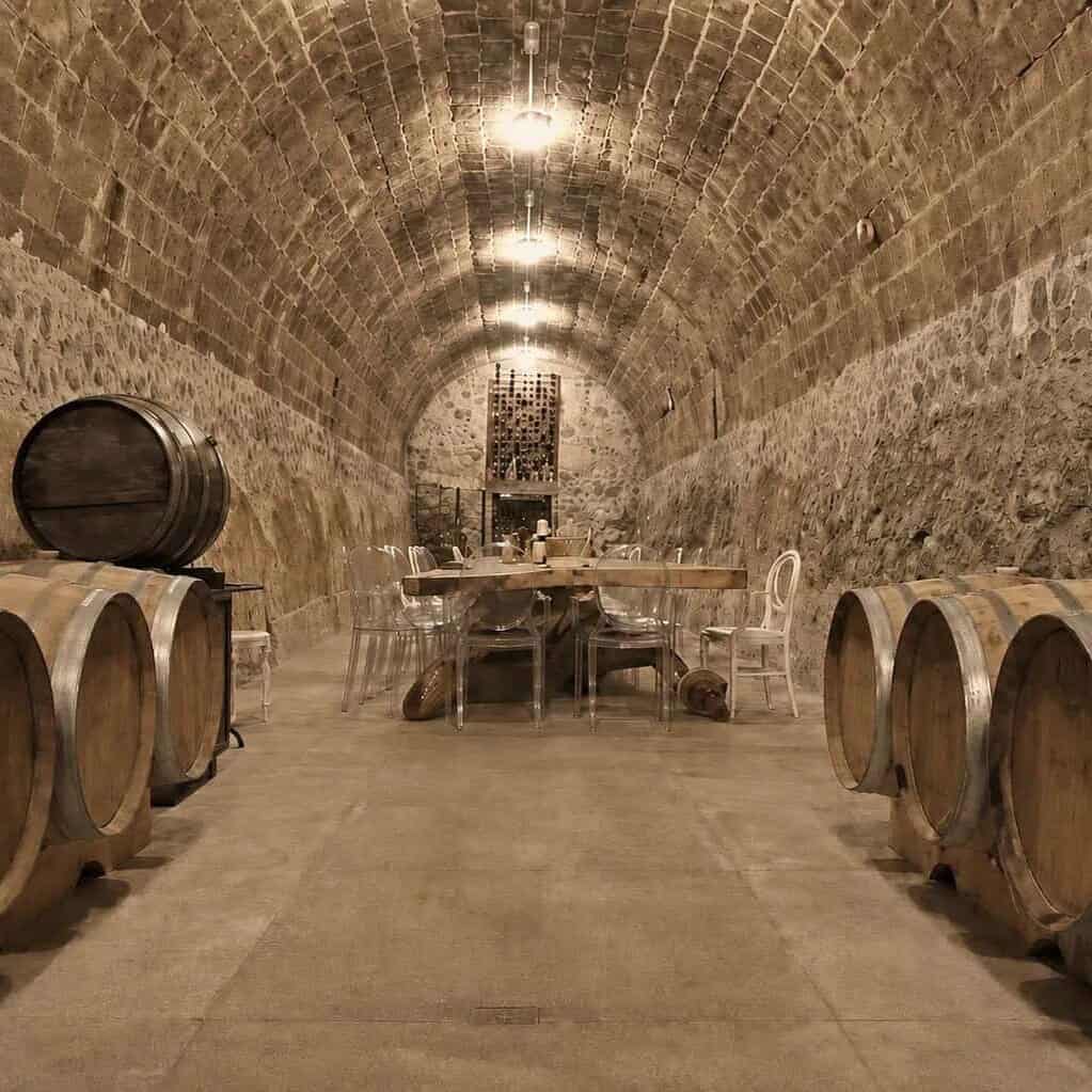 Cava con barricas de roble bajo una b&oacute;veda de piedra.