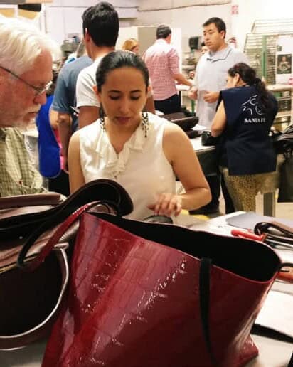 Visitantes observan la elaboración de bolsas de piel en un taller de León, Guanajuato.