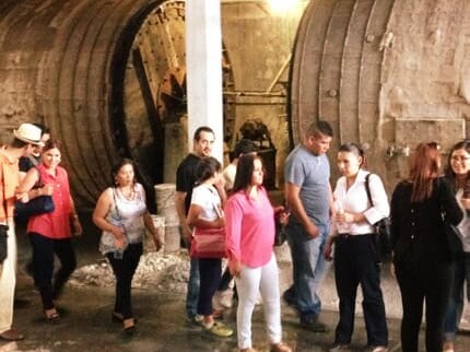 Group of visitors next to the tanning drums in a tannery in León, Guanajuato.