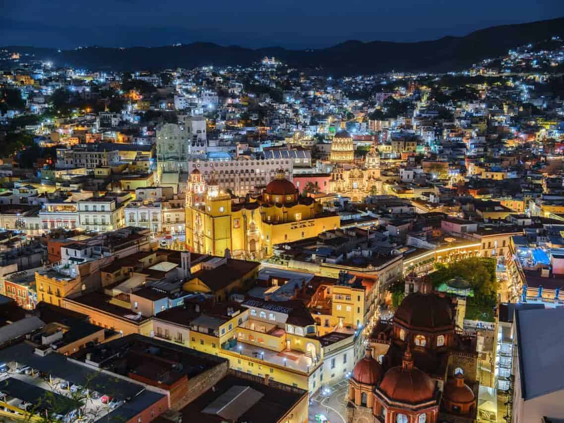 Vista nocturna de la ciudad de Guanajuato con la Basílica de Nuestra Señora de Guanajuato iluminada.