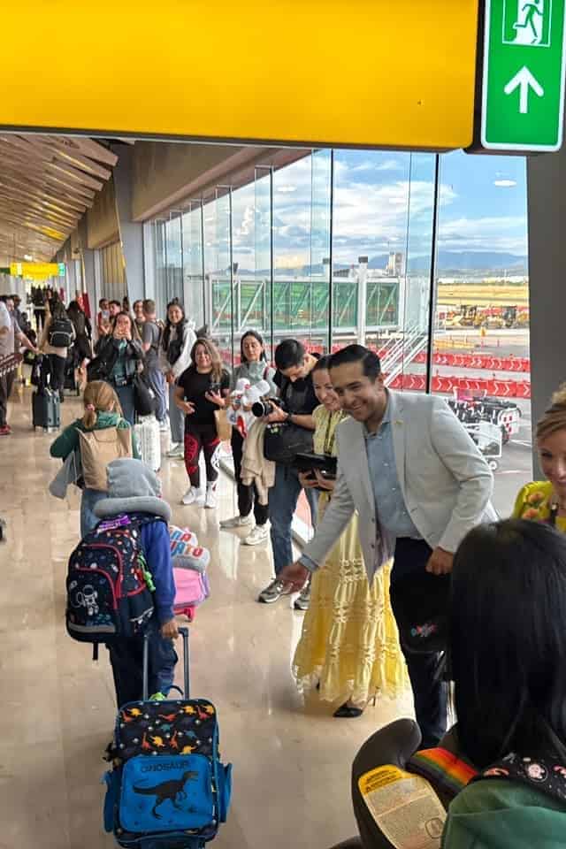 Turistas en aeropuerto de Guanajuato con vista a la pista y salida hacia Canadá.
