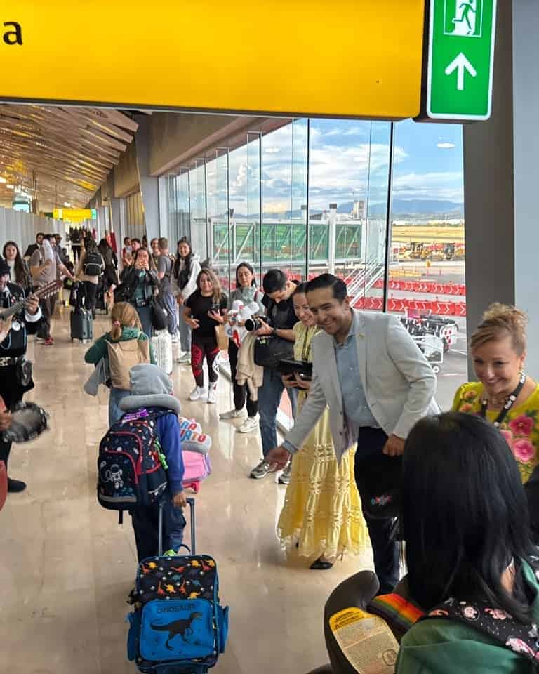 Turistas en aeropuerto de Guanajuato con vista a la pista y salida hacia Canadá.