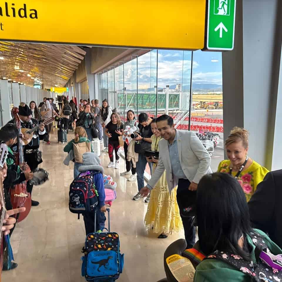 Turistas en aeropuerto de Guanajuato con vista a la pista y salida hacia Canadá.
