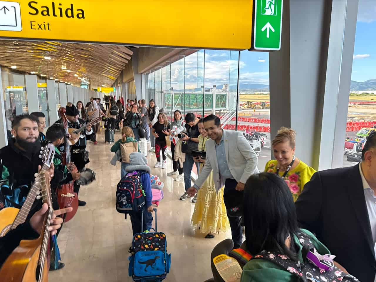 Tourists at Guanajuato airport with a view of the runway and a departure to Canada.