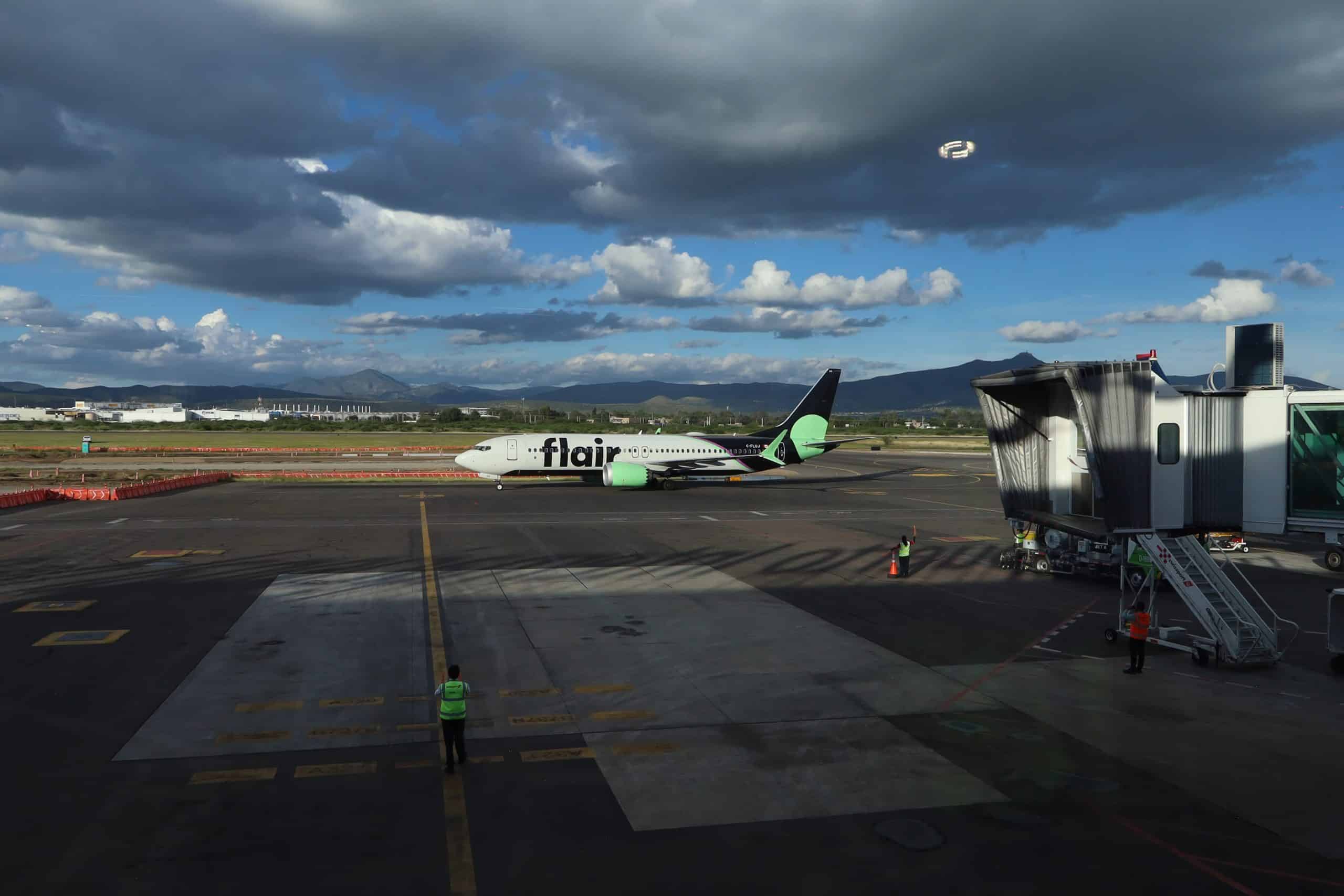 Avión de Flair Airlines en aeropuerto de Guanajuato con cielo nublado.