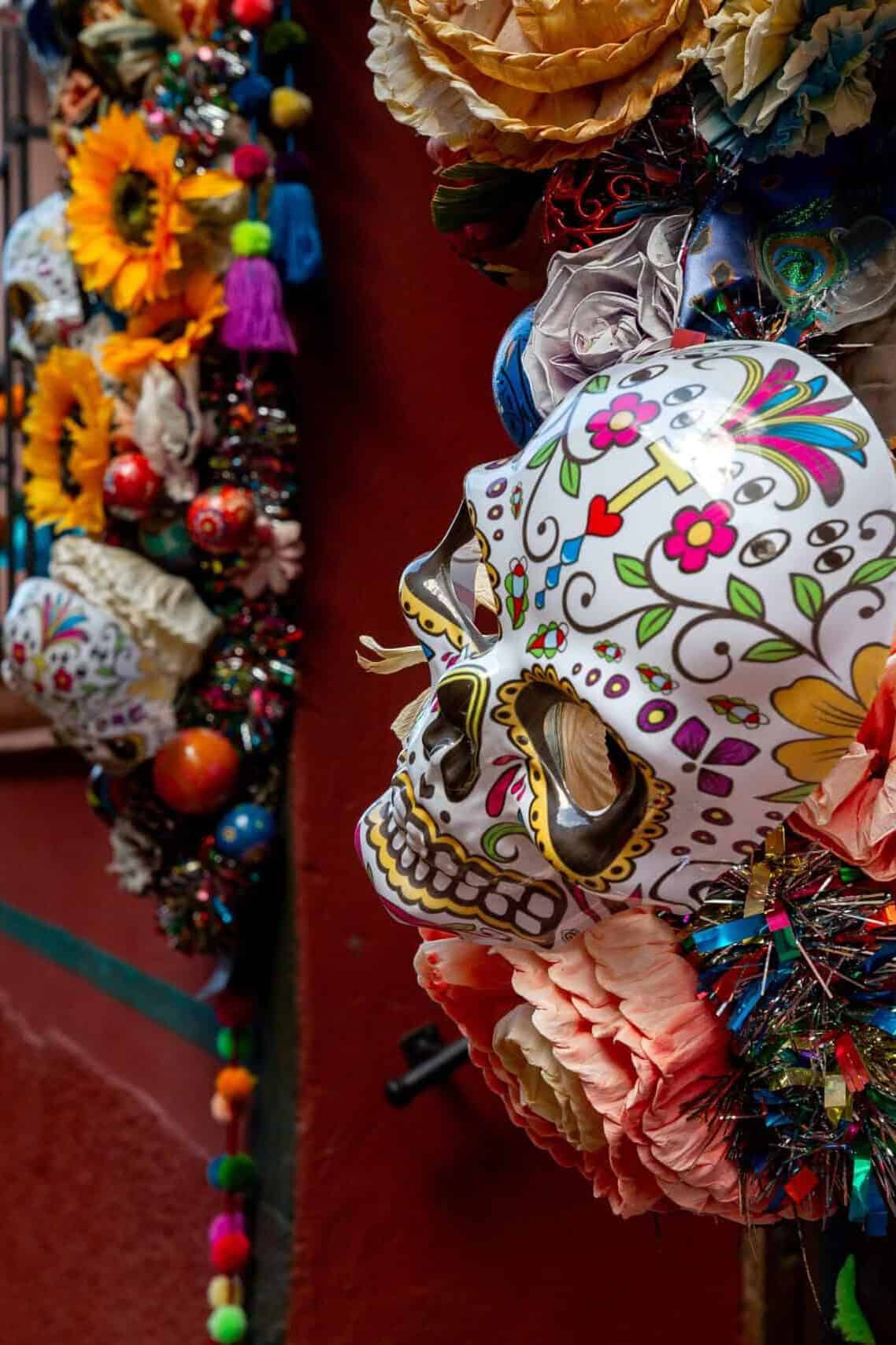 Calavera decorada y colorida en una calle de Guanajuato, arte festivo y sombreros de papel picado.