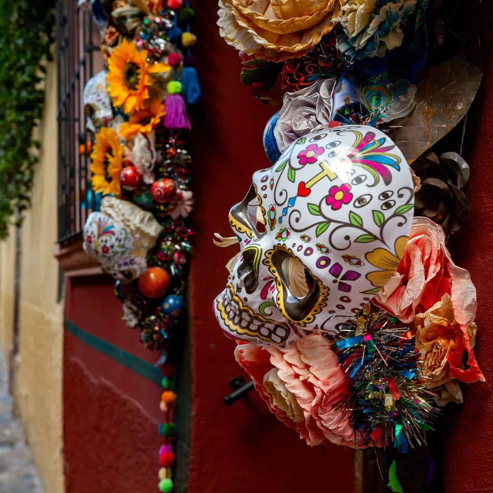Calavera decorada y colorida en una calle de Guanajuato, arte festivo y sombreros de papel picado.