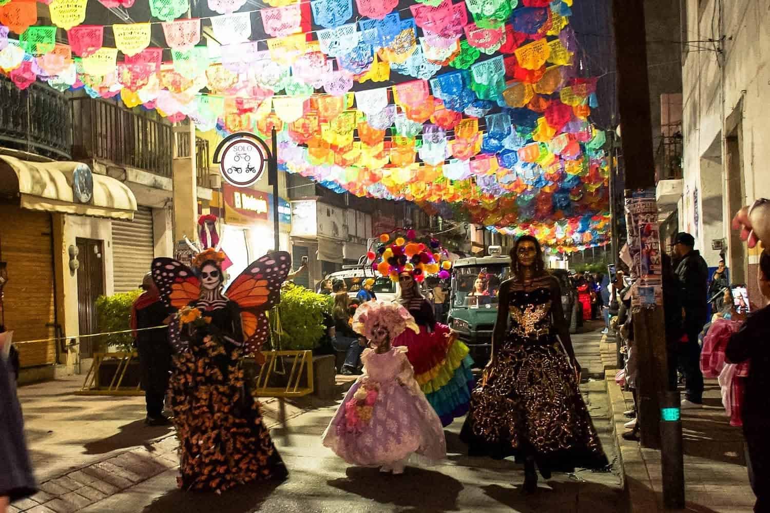 Celebración del Día de Muertos en Guanajuato con catrinas y decoraciones coloridas.