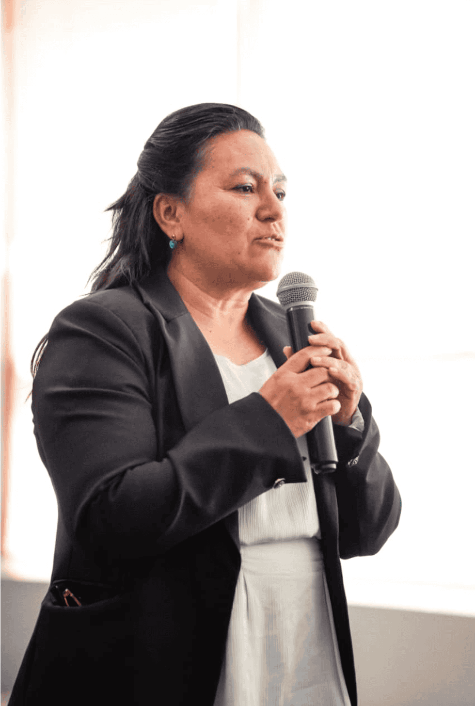 Mujer hablando en micrófono durante un evento de turismo en Jalpa de Cánovas.