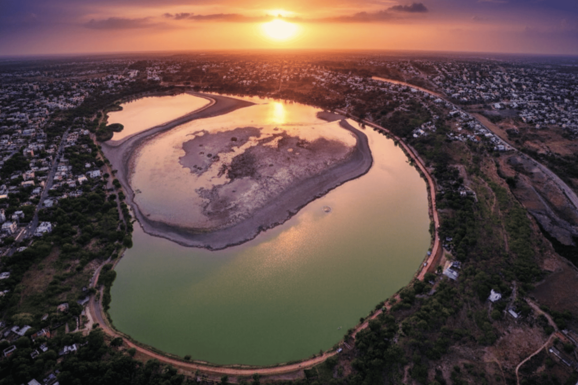 Beautiful aerial view of the river in Guanajuato at sunset, reflecting the orange and pink sky.