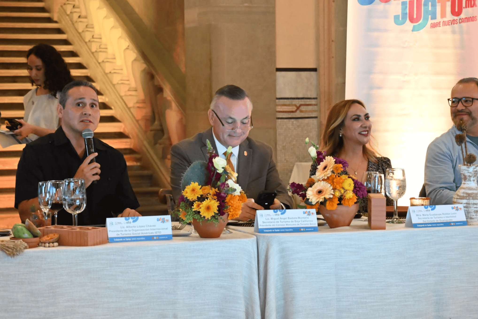 Participantes en evento de turismo social en Guanajuato con flores y micrófono.