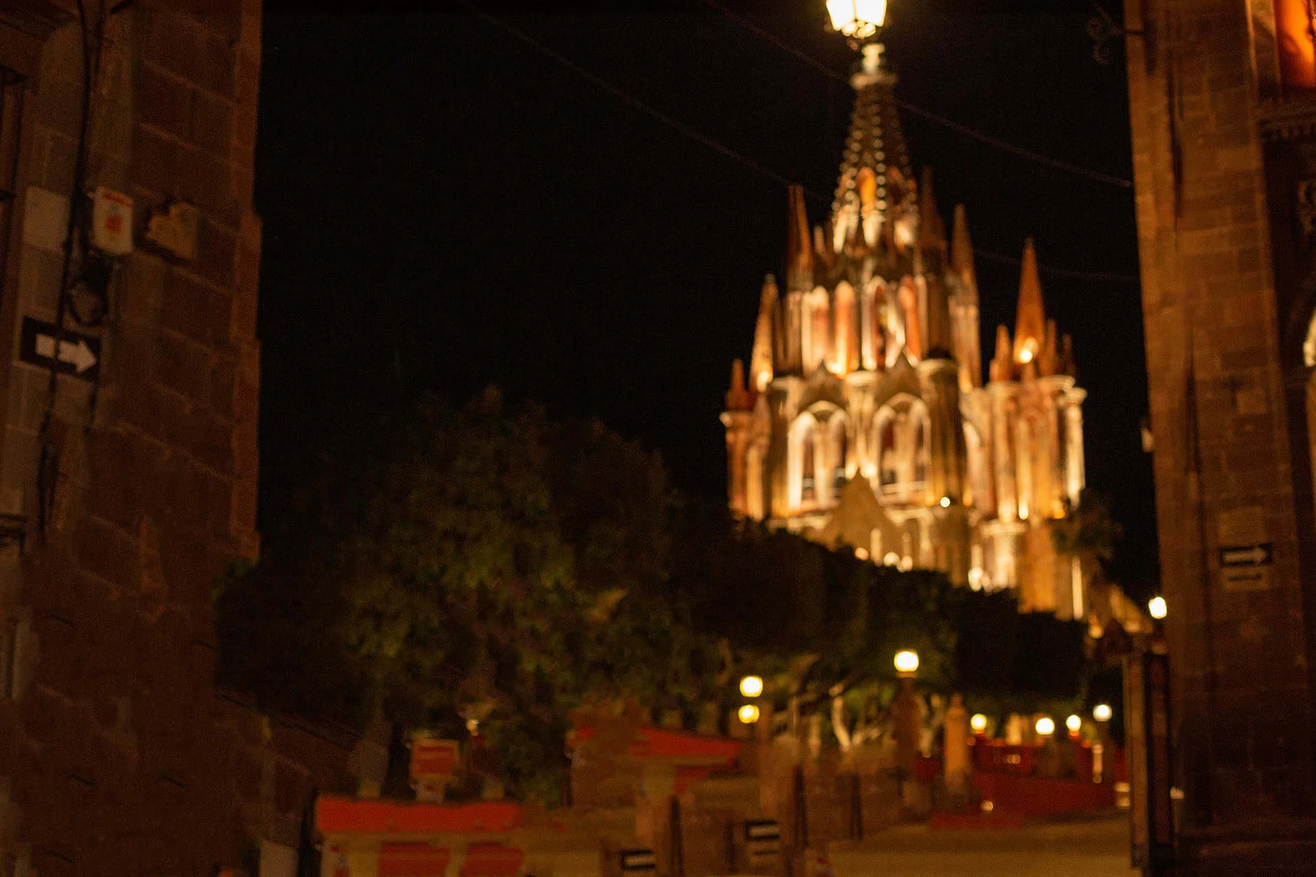 Catedral de Guanajuato iluminada en la noche, vista desde un callejón histórico.